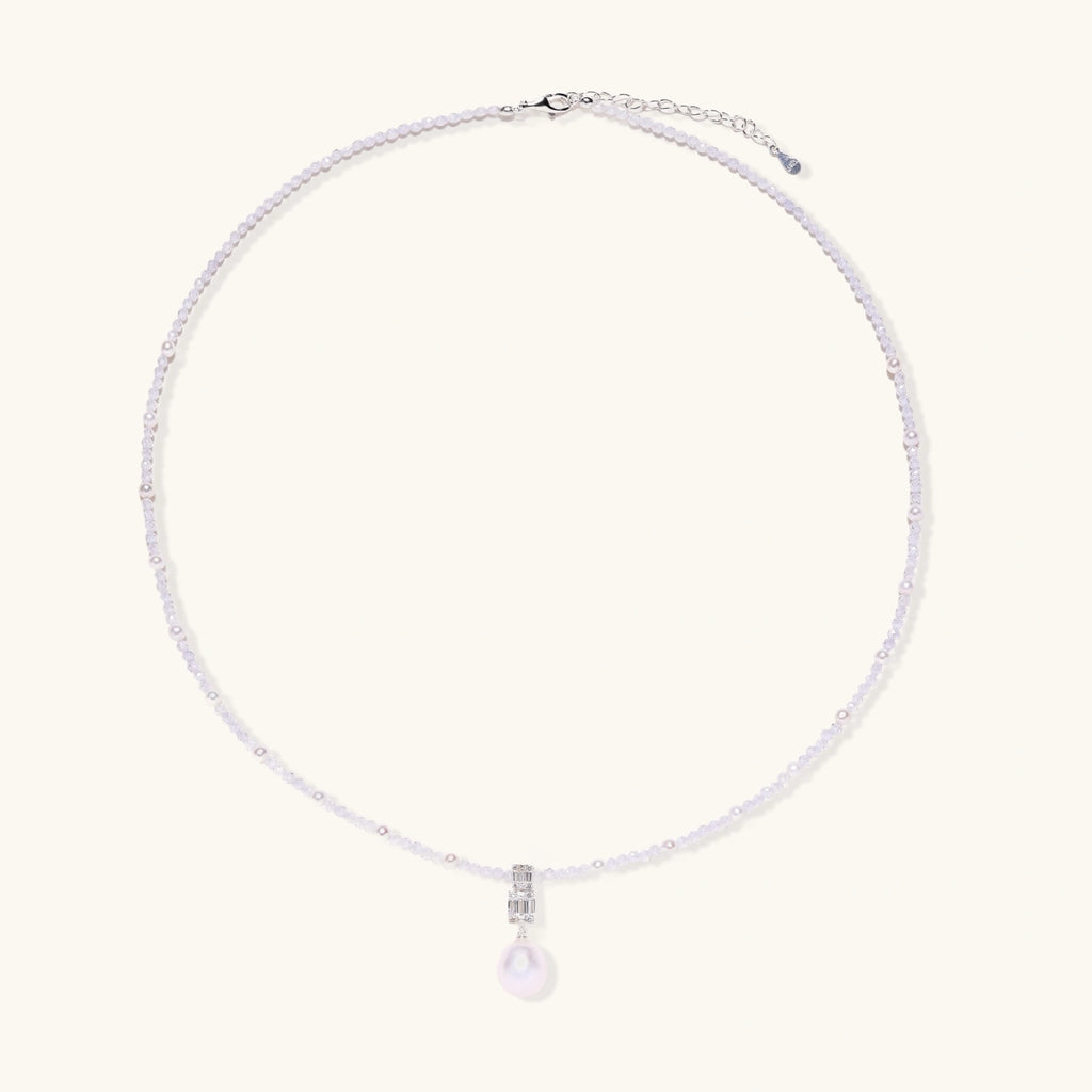 Dainty necklace with lavender crystal beads, freshwater pearls, geometric pendant, and large pearl drop on white background.