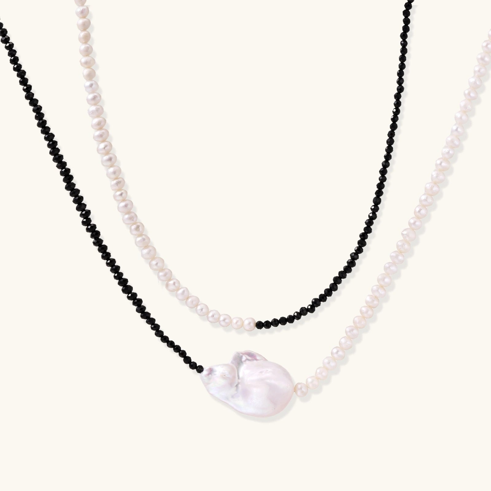 Double-strand necklace with black faceted quartz and white pearls featuring an oversized baroque pearl centerpiece