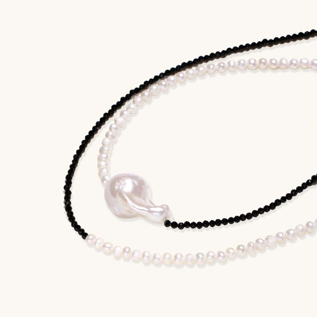 Double-strand necklace with black faceted quartz and white pearls featuring an oversized baroque pearl centerpiece