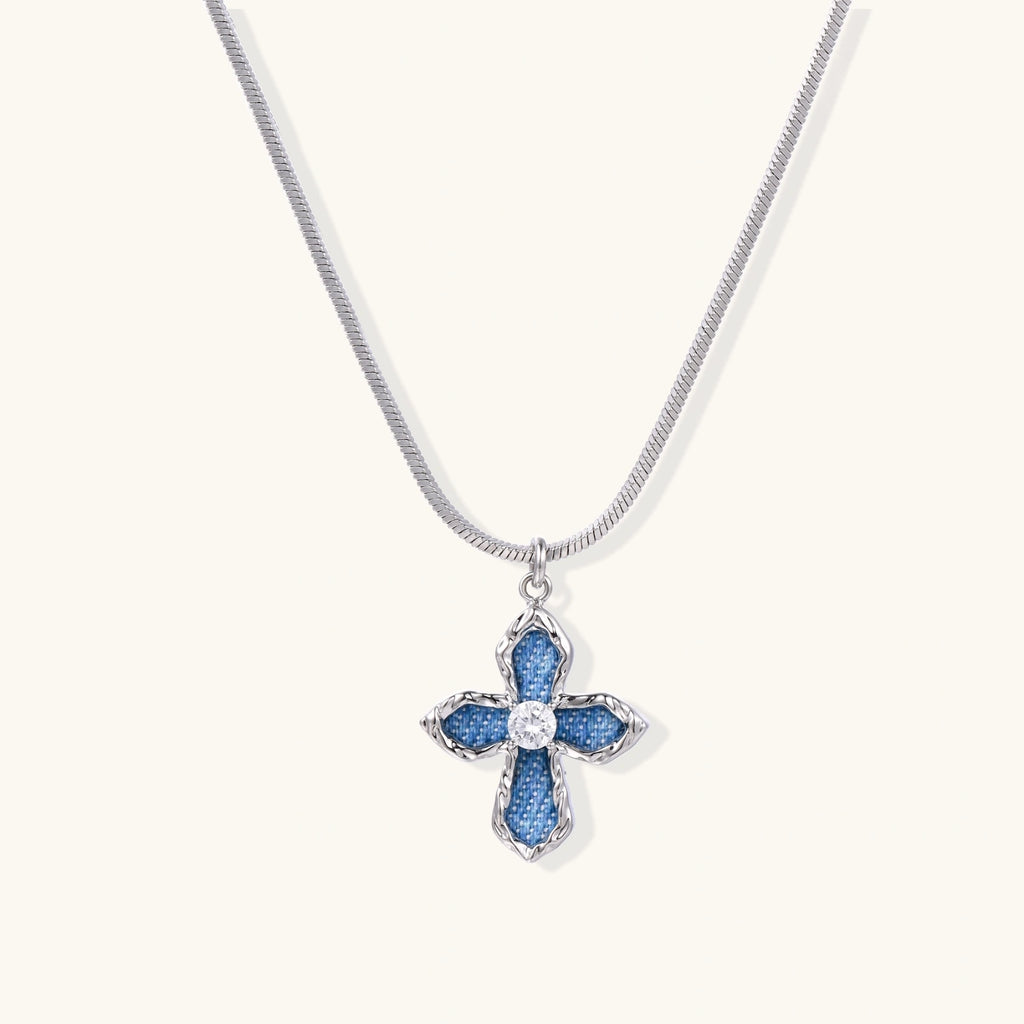 White gold plated cross pendant with blue denim fabric inlays and central zirconia crystal on adjustable chain
