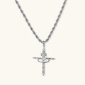 Silver-tone necklace with dimensional orb pendant, cross crown detail, and zirconia stones on twisted rope chain