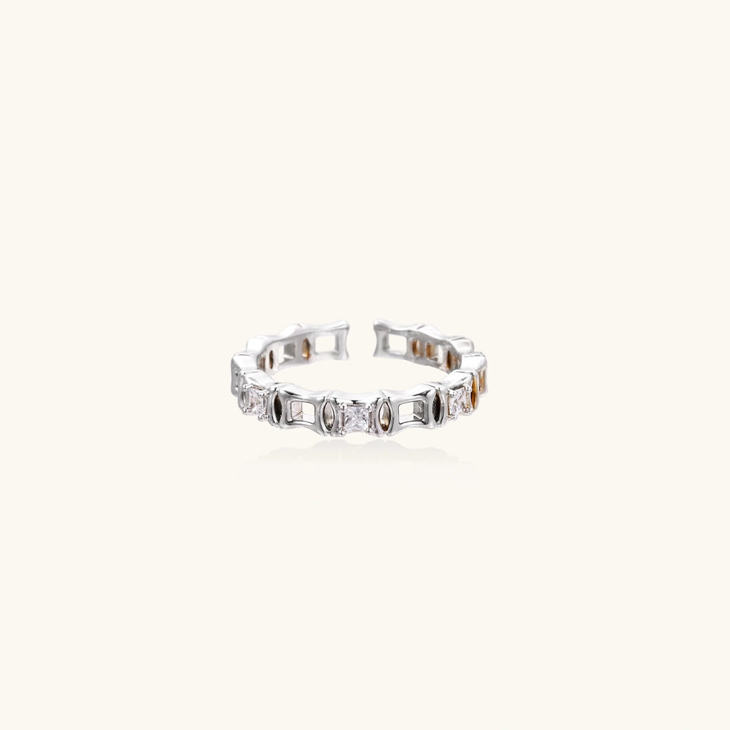 White gold plated ring with architectural lattice design and zirconia accents on cream background