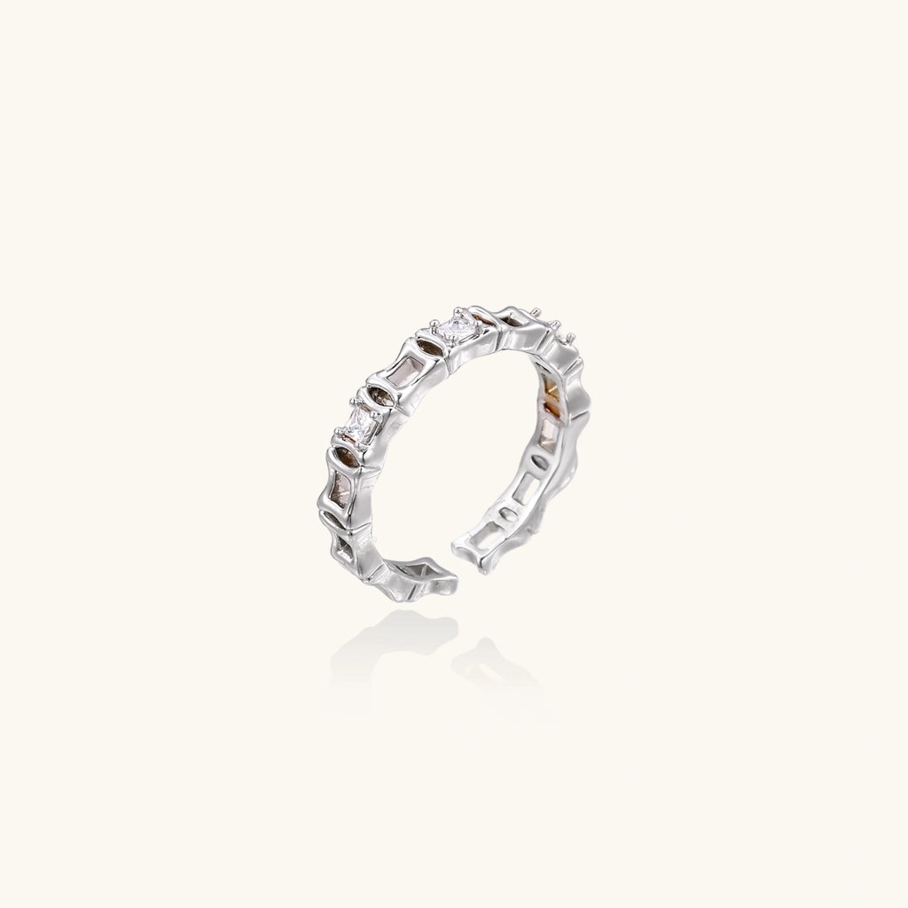 White gold plated ring with architectural lattice design and zirconia accents on cream background