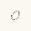 White gold plated ring with architectural lattice design and zirconia accents on cream background