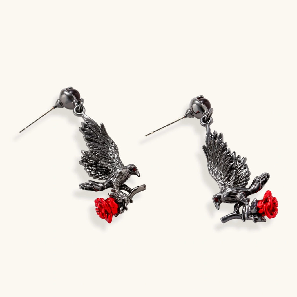 Dark gunmetal raven earrings with red rose details, featuring detailed bird wings and S925 silver posts on cream background.